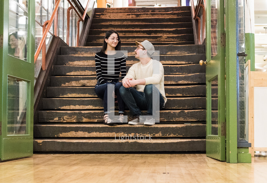 a couple sitting in a stairwell 