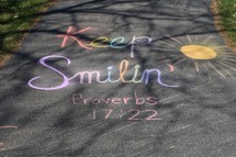 Proverbs 17:22 in chalk on the sidewalk