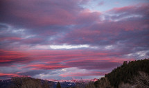 pink clouds over mountains at sunset 