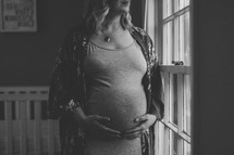 pregnant woman standing in a baby nursery 