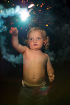toddler holding a sparkler firework 