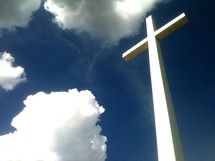 The reach of the cross - The Cross reaching from Heaven to Earth surrounded by blue skies and clouds showing the height and depth of Jesus love to come down from Heaven to Earth and give His only Son as a sacrifice for our sins so that we may be restored and spend eternity in Heaven with Jesus. 