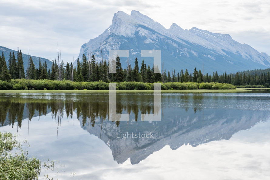 reflection of mountain peaks on lake water 