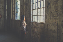 woman standing in an empty warehouse 