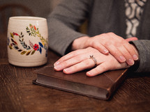 a woman with her hands on a Bible 