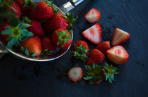 cut strawberries, knife, and a strainer 