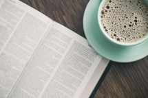 coffee cup and page of a Bible 