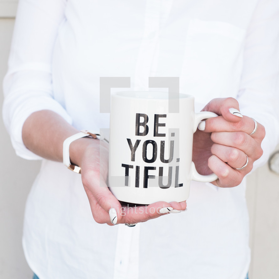 woman holding a mug with the words Be. You. Tiful. 