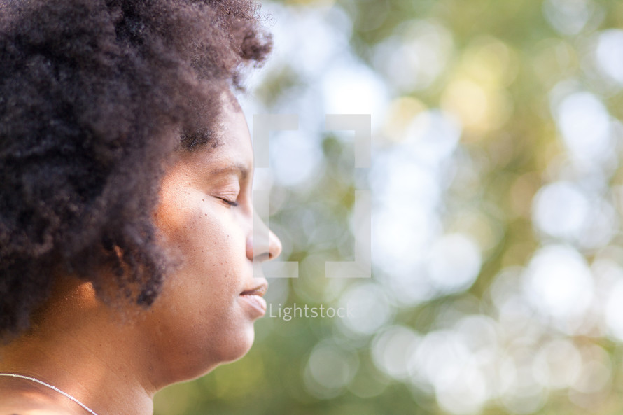 side profile of an African American woman with eyes closed in prayer 