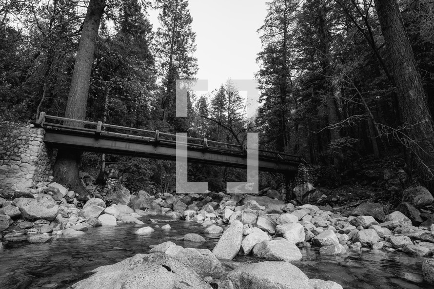 Bridge over rocky stream - black and white