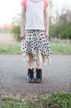 legs of a teen girl in boots and skirt 