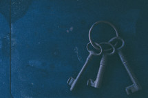 Set of old keys arranged on textured metal top.