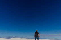 a man looking up to God standing on sand dunes 