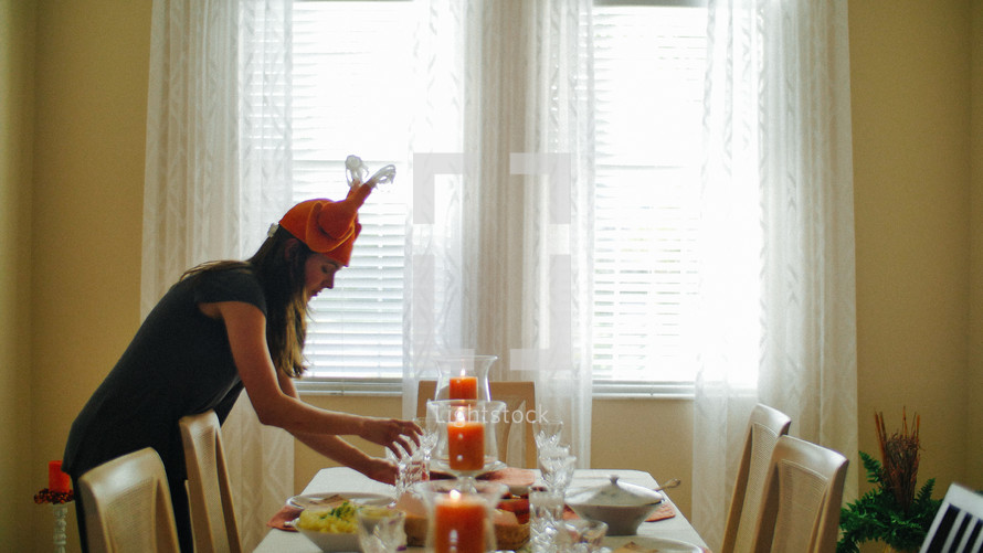 A woman setting a table for thanksgiving 