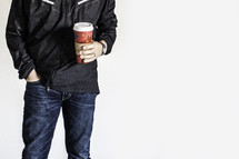 torso of man holding a coffee travel mug