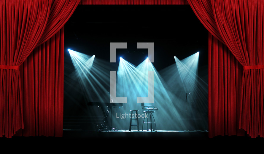 Spotlights on a stage with red curtains.