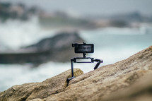 camera on a tripod on rocks 