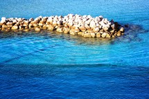 ice blue water against a rock jetty