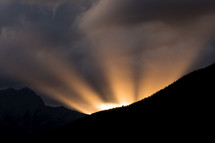 rays of light behind a mountain at sunrise 