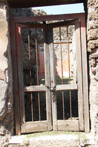 Wooden gate with a chain lock on a stone building.