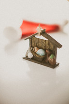 The Manger scene in front of a red Santa hat