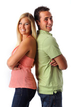 smiling young couple standing back to back