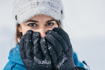 woman with gloves covering her face 