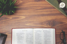 open Bible and reading glasses on a wood table - Isaiah