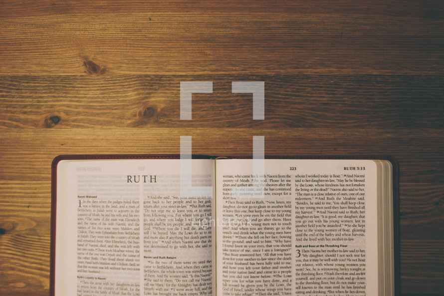 Bible on a wooden table open to the book of Ruth.