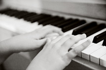 Two hands playing a piano.