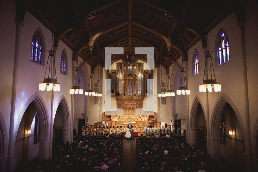 A filled chapel during a wedding ceremony