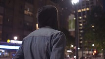 a man walking through a city at night 