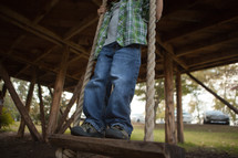Boy standing on swing