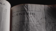Light revealing a Bible and the book of Genesis