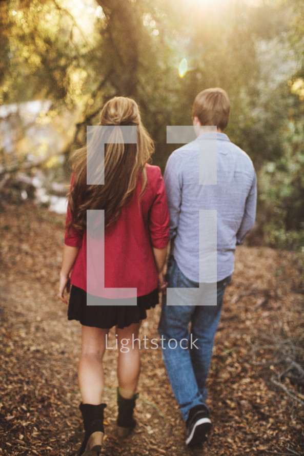 couple walking on an outdoor path holding hands