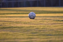 soccer ball on a glowing field at sunset 