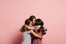 mother and daughters hugging 