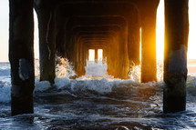 waves crashing into pier posts 