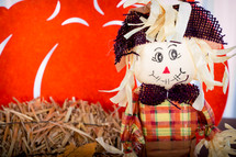 a scarecrow and hay fall decorations 
