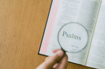 magnifying glass over Psalms in an open Bible 