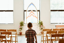 a boy walking in an empty church 