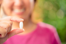 a woman holding a pill 