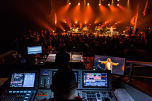 production crews controlling lights and sound at a concert 