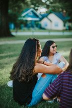 group of women talking sitting in grass 
