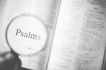 magnifying glass over Psalms in an open Bible 