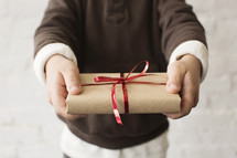 a young boy holding a wrapped Christmas gift 
