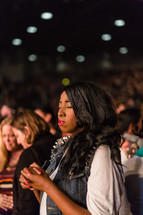 African American young woman in an audience praying 