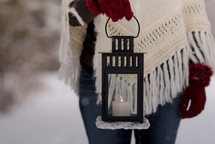 a woman holding a lantern in the snow
