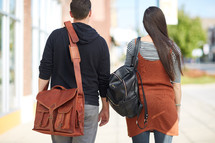man and woman walking carrying bags 