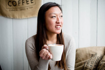 A young woman holding a cup of coffee.